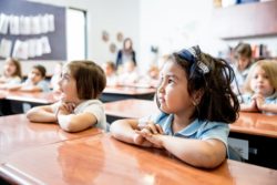 students sitting at their desks with their hands folded
