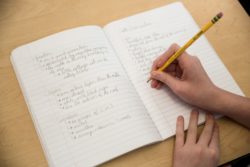 student writing in a notebook