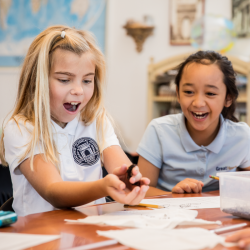 girl at desk holding worm